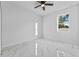 Bright bedroom with white walls, a window with natural light, and marble-style tile flooring at 833 Texas Ave, Lakeland, FL 33815