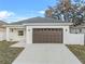 Charming single Gathering home featuring a gray roof, brown garage door, and a large driveway at 833 Texas Ave, Lakeland, FL 33815