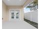 An inviting back porch featuring white framed glass doors and a privacy fence at 835 Texas Ave, Lakeland, FL 33815