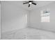 Neutral bedroom with ceiling fan, bright window, white walls, and marble tile flooring at 835 Texas Ave, Lakeland, FL 33815