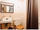 Standard bathroom with peach-colored tile, sink, toilet, and curtained shower at 922 Se 13Th St, Ocala, FL 34471