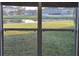 Bright window view overlooking a serene backyard pond and neighboring houses at 1907 Eliza Ann St, Kissimmee, FL 34758