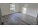 Bright bedroom with gray plank flooring and a window overlooking the lawn at 1907 Eliza Ann St, Kissimmee, FL 34758