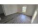 Well-lit bedroom featuring hardwood floors and a large window overlooking the front yard at 1907 Eliza Ann St, Kissimmee, FL 34758