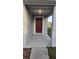 Covered front porch with a solid wood door and neutral color scheme at 1907 Eliza Ann St, Kissimmee, FL 34758