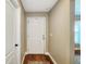 Neutral-toned hallway with wood floors, a white front door, and access to additional rooms at 6830 Krenson Oaks Cir, Lakeland, FL 33810