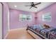 Bedroom featuring violet paint, neutral tile floors, ceiling fan, and natural wood furniture at 1220 George St, Winter Springs, FL 32708