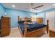 Cozy bedroom featuring blue walls, neutral tile floors, ceiling fan, and traditional wood furniture at 1220 George St, Winter Springs, FL 32708