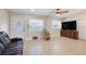 Inviting living room with a rocking chair, tile flooring, and a view of the decorative front door at 1220 George St, Winter Springs, FL 32708