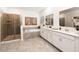 Bright bathroom featuring double sinks, a soaking tub with tile surround, and glass enclosed shower at 282 Puma Loop, Groveland, FL 34736