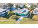 Aerial view of a green home and neighborhood with a pool in the backyard at 38 Seaside Dr, Ormond Beach, FL 32176