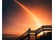 Scenic beach featuring person sitting on stairs watching a rocket launch at dusk at 38 Seaside Dr, Ormond Beach, FL 32176