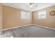 Neutral bedroom featuring gray carpet, ceiling fan, and two bright, windowed walls at 38 Seaside Dr, Ormond Beach, FL 32176