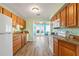 Well-equipped kitchen with wooden cabinets, granite countertops, white appliances, and a view into the dining area at 38 Seaside Dr, Ormond Beach, FL 32176