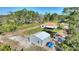 Aerial view of home, shed, and large landscaped lot with mature trees and manicured lawn at 4101 Poinciana Dr, Indian Lake Estates, FL 33855