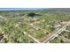 High-angle view of the property near a road intersection, with a glimpse of a lake in the distance at 4101 Poinciana Dr, Indian Lake Estates, FL 33855