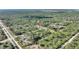 Aerial shot displays a home bordered by a blend of grassy areas and a dense, verdant forest backdrop at 4101 Poinciana Dr, Indian Lake Estates, FL 33855