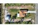 Overhead view of the property with a well-maintained roof, driveway, lush lawn, and an additional structure nearby at 4101 Poinciana Dr, Indian Lake Estates, FL 33855