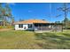 Well-kept backyard featuring a screened porch area perfect for enjoying the outdoors, along with a large grassy expanse at 4101 Poinciana Dr, Indian Lake Estates, FL 33855