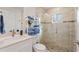 Modern bathroom featuring a glass shower, stone floor, white vanity, and open shelving for towels and decorative items at 4101 Poinciana Dr, Indian Lake Estates, FL 33855