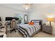 Neutral colored bedroom with ceiling fan, large window and desk area for gaming setup at 4101 Poinciana Dr, Indian Lake Estates, FL 33855