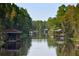 A tranquil canal scene with multiple wooden boathouses surrounded by lush green trees at 4101 Poinciana Dr, Indian Lake Estates, FL 33855