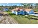 Exterior shot of a single-story home with a manicured lawn, an attached garage, and a detached garage at 4101 Poinciana Dr, Indian Lake Estates, FL 33855