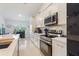 Well-lit kitchen showcasing stainless steel appliances, white cabinetry, and a view to the outside at 4101 Poinciana Dr, Indian Lake Estates, FL 33855