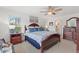 Airy main bedroom with two windows, ceiling fan, en suite bathroom and traditional-style furniture at 4101 Poinciana Dr, Indian Lake Estates, FL 33855