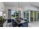 Elegant dining area with a chandelier, large windows, and views of the outdoor pool at 5243 Sw 88Th Cir, Ocala, FL 34481