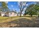 Spacious backyard with mature trees and a view of the home's rear exterior at 1422 Connestee Rd, Lakeland, FL 33805