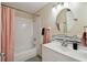 Bright bathroom featuring a shower, white vanity with a modern sink, and a sleek round mirror at 1422 Connestee Rd, Lakeland, FL 33805