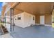 Spacious carport area featuring durable flooring, white doors, and metal support beams adding protection from the elements at 1422 Connestee Rd, Lakeland, FL 33805