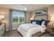 Calm main bedroom with large window offering view, ceiling fan, and neutral decor at 2513 Penguin Blvd, Davenport, FL 33837