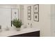 Bathroom featuring double sinks, a granite countertop, and modern fixtures; decorated with floral art at 2908 Transformation Way, Clermont, FL 34714