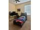 Bedroom with a bed, desk, and large window offering natural light at 3088 Pointe Place Ave, Kissimmee, FL 34758