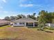 View of the backyard featuring a screened-in lanai and simple landscaping on a large lot at 562 Dowling Cir, Lady Lake, FL 32159