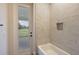 This bathroom features a tub with tiled walls and a window view at 562 Dowling Cir, Lady Lake, FL 32159