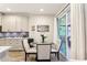 Bright dining area featuring a glass table, white chairs, and sliding glass doors to the kitchen and backyard at 562 Dowling Cir, Lady Lake, FL 32159