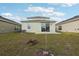 Backyard of home with green lawn, exterior view of house, and partial view of neighboring properties at 6973 Wilson Pasture Ave, Groveland, FL 34736