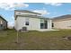 Home's backyard featuring a well-maintained lawn and a view of the property's exterior at 6973 Wilson Pasture Ave, Groveland, FL 34736