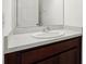 Close-up of a bathroom vanity with a white countertop and dark wood cabinets at 6973 Wilson Pasture Ave, Groveland, FL 34736