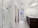 Bathroom featuring tiled floors, glass shower door, double sinks, and dark wood cabinets at 6973 Wilson Pasture Ave, Groveland, FL 34736