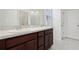 Bathroom with double sinks, a large mirror, and dark wood cabinets at 6973 Wilson Pasture Ave, Groveland, FL 34736