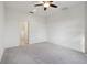 Light-filled bedroom featuring gray carpet, a ceiling fan, and an ensuite bathroom at 6973 Wilson Pasture Ave, Groveland, FL 34736