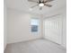 Well-lit bedroom with carpet, a ceiling fan, window, and a built-in closet for storage at 6973 Wilson Pasture Ave, Groveland, FL 34736