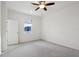 Bright bedroom featuring neutral carpet, a ceiling fan, and a large window at 6973 Wilson Pasture Ave, Groveland, FL 34736