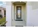 Inviting entryway with a glass-paneled front door and neutral-colored columns at 6973 Wilson Pasture Ave, Groveland, FL 34736