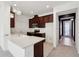 Modern kitchen featuring dark wood cabinets, stainless steel appliances, and a white quartz countertop island at 6973 Wilson Pasture Ave, Groveland, FL 34736