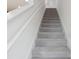 Carpeted staircase with white walls and handrail at 6973 Wilson Pasture Ave, Groveland, FL 34736